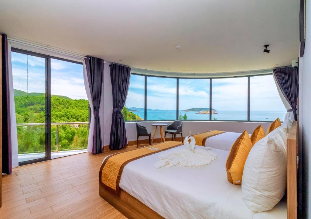 a bedroom with a large bed with a large window at RUBEACH HOTEL & REROST in Song Cau