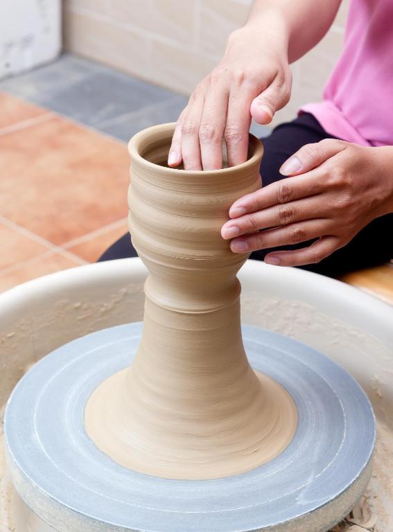 a woman making a vase on a pottery wheel at Family Pottery in Hengchun South Gate