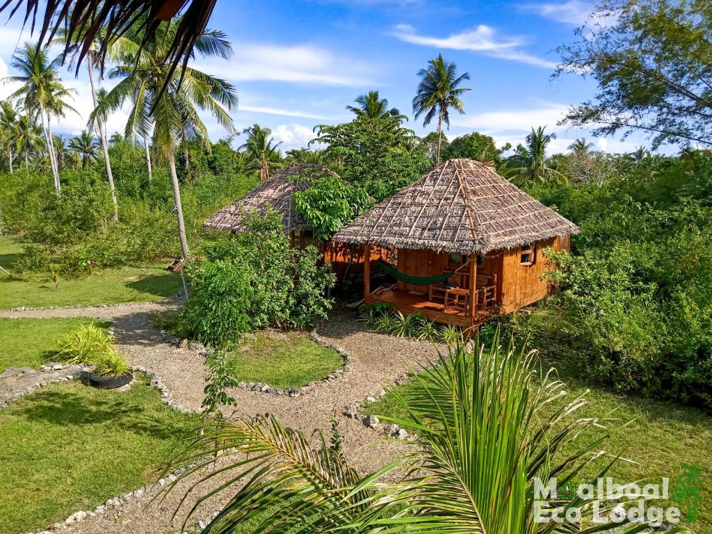 une petite cabane avec un toit de chaume dans un jardin dans l'établissement Moalboal Eco Lodge, à Moalboal