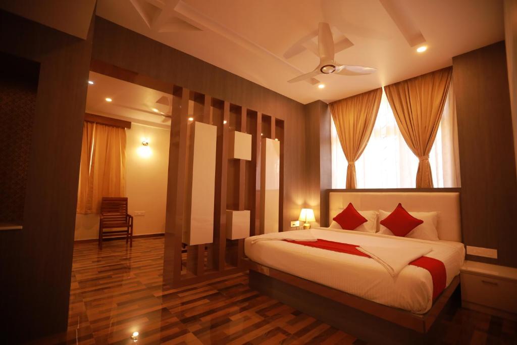 een slaapkamer met een bed met rode kussens en een raam bij Sree Bharat Residency in Alāndurai