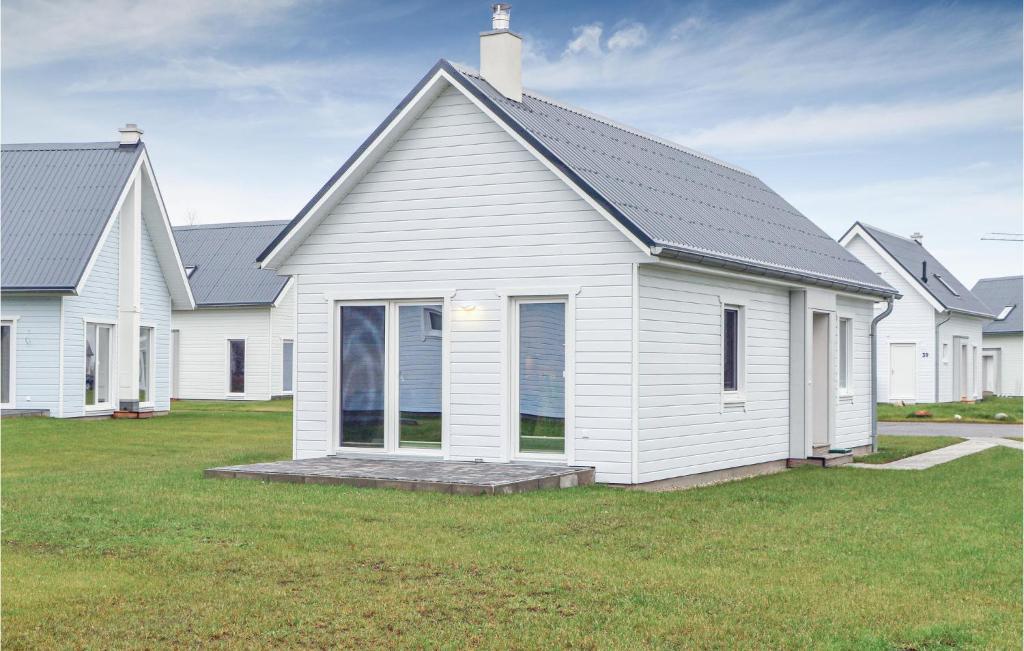 a white house with a porch on a lawn at Cozy Home In Ostseeresort Olpenitz in Olpenitz