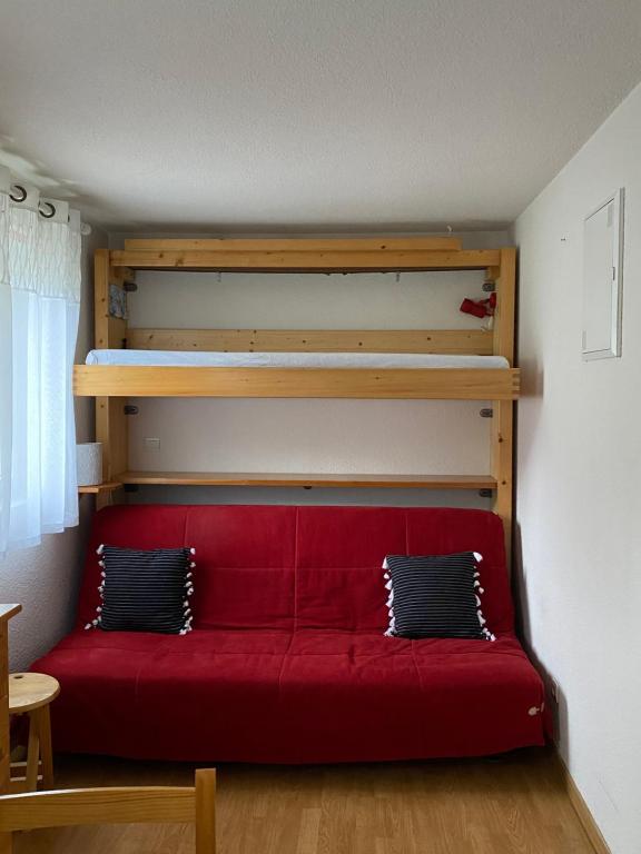 a red couch in a room with a bunk bed at Studio Font-Romeu avec place de parking in Font-Romeu-Odeillo-Via