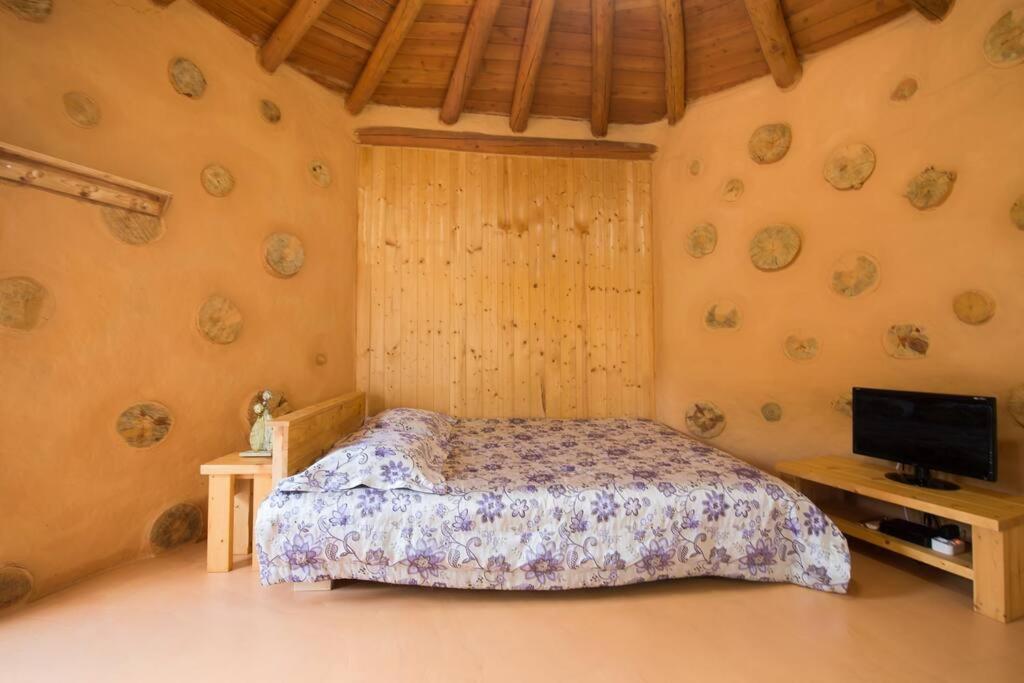 a bedroom with a bed and a flat screen tv at Red Clay pension in Gangneung