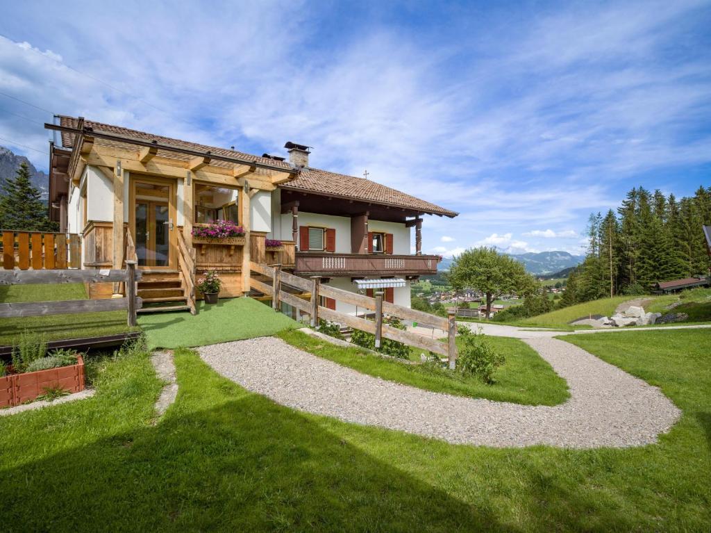 a house on a hill with a path leading to it at Appartement Waldmoos in Ellmau