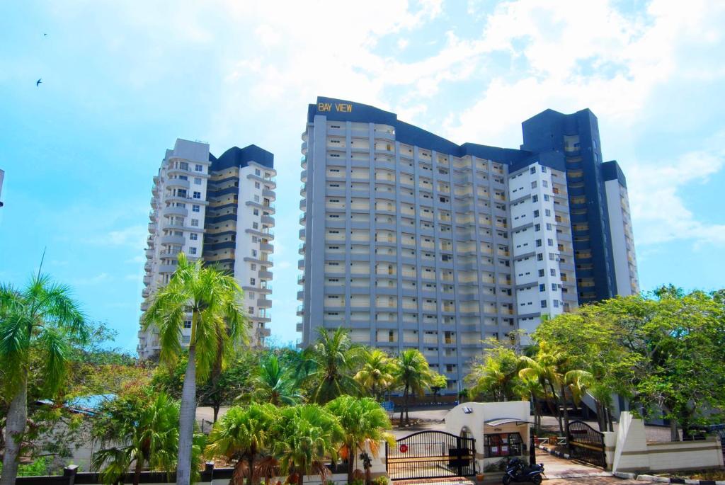 dos edificios altos en una ciudad con palmeras en Maya Apartment Bay View Villas, en Port Dickson
