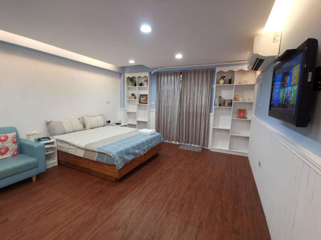 台南的住宿－雅舍公寓，一间卧室配有一张床、一台电视和一张沙发