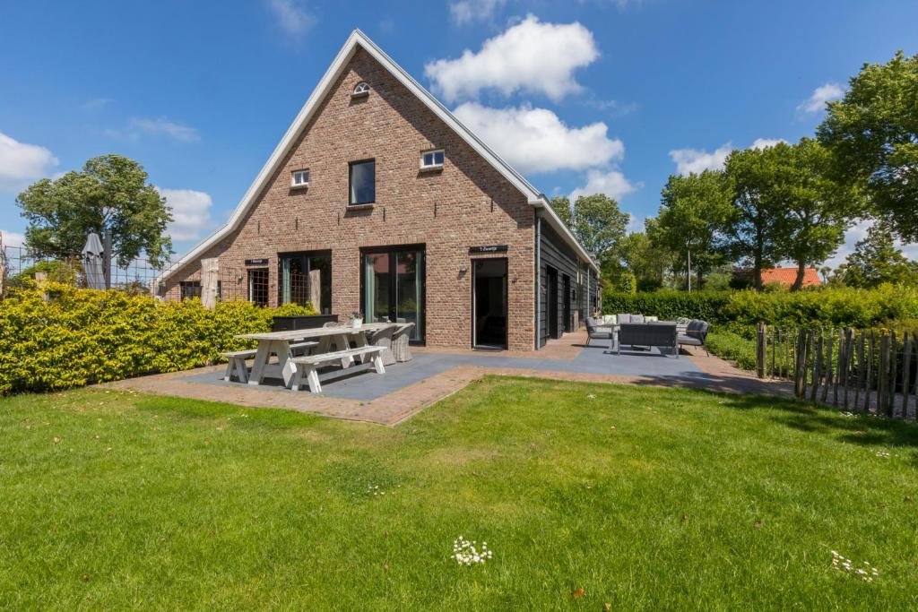 a brick building with benches in a yard at Welcome in - Vakantiehuis - Lepelstraat 18A 't Blauwtje in Vrouwenpolder