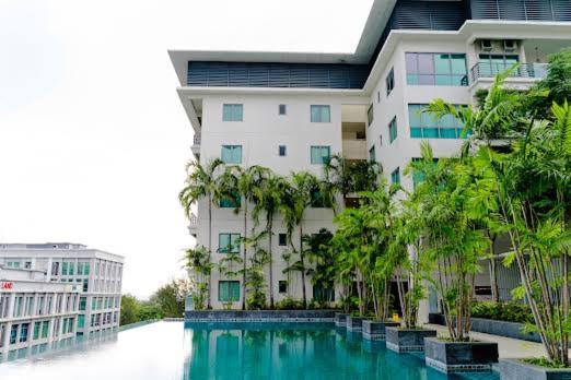un bâtiment avec une piscine en face d'un bâtiment dans l'établissement Bulan Guesthouse Imago, à Kota Kinabalu