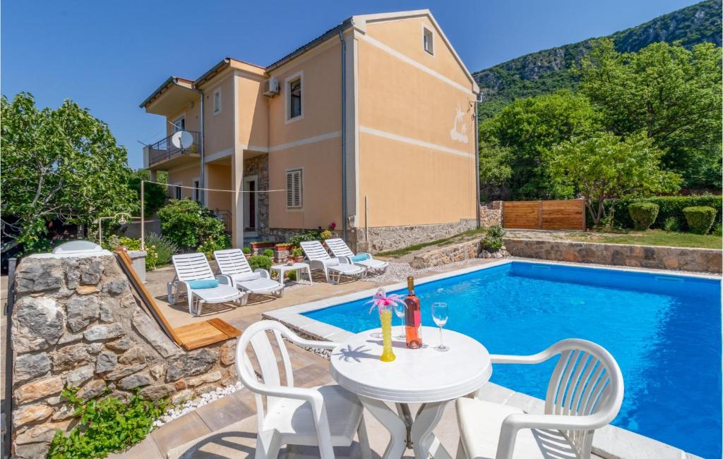 a patio with a table and chairs next to a pool at Cozy Home In Grizane With Kitchen in Grižane