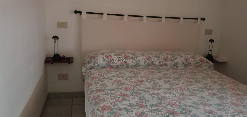 a bedroom with a bed with a floral bedspread at La casetta di Kamma in Kamma