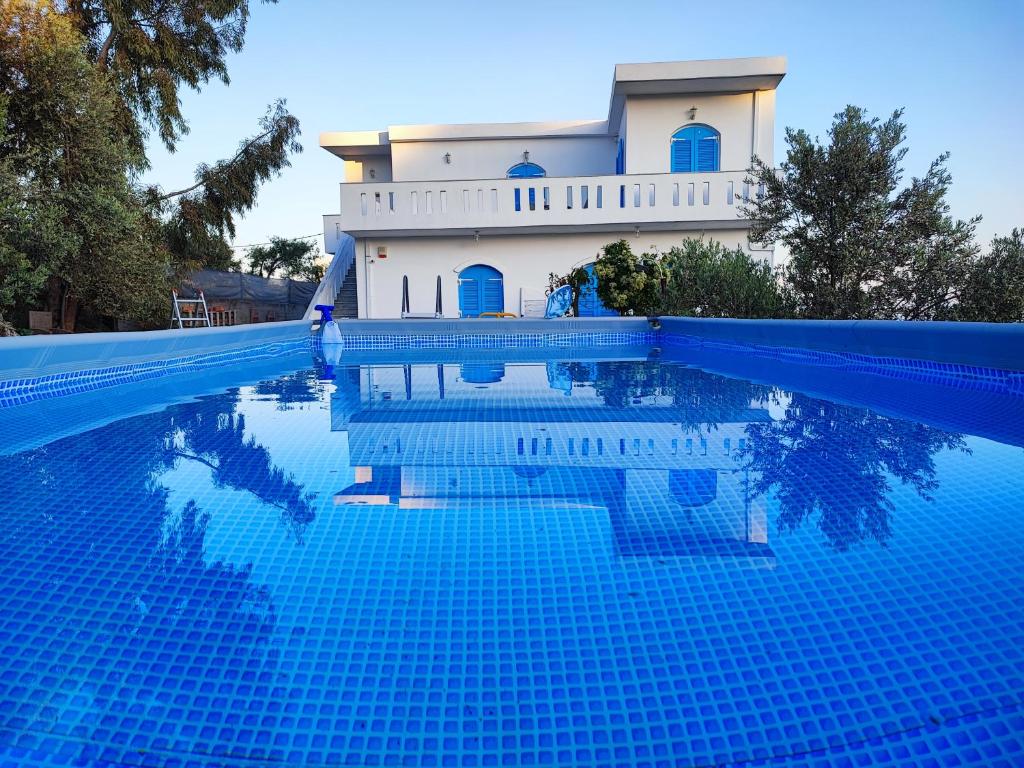 a villa with a swimming pool in front of a house at VILLA KARA - Bed and Breakfast in Mési