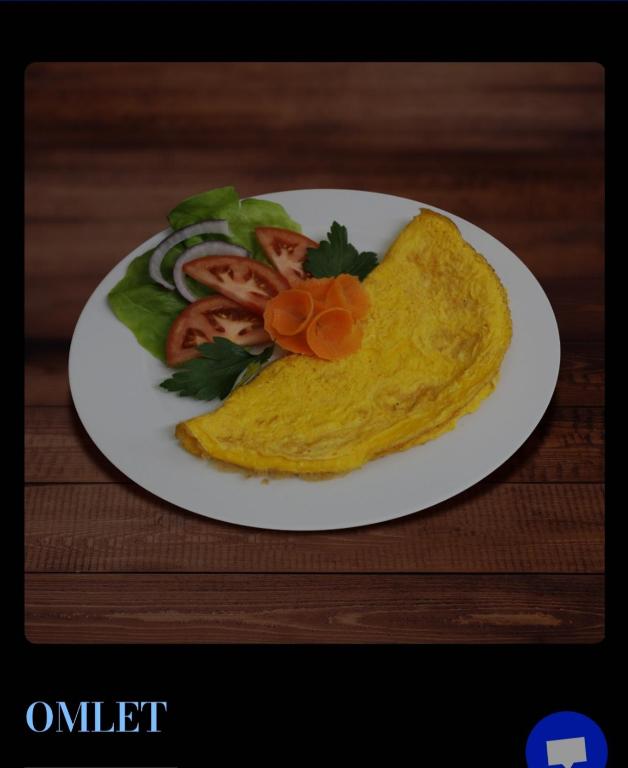 a white plate with an omelet with tomatoes and vegetables at Greenspace in Niš