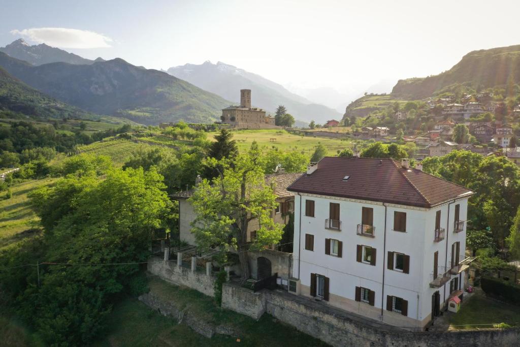 uma casa num vale com montanhas ao fundo em Cascina Des Religieuses em Aosta