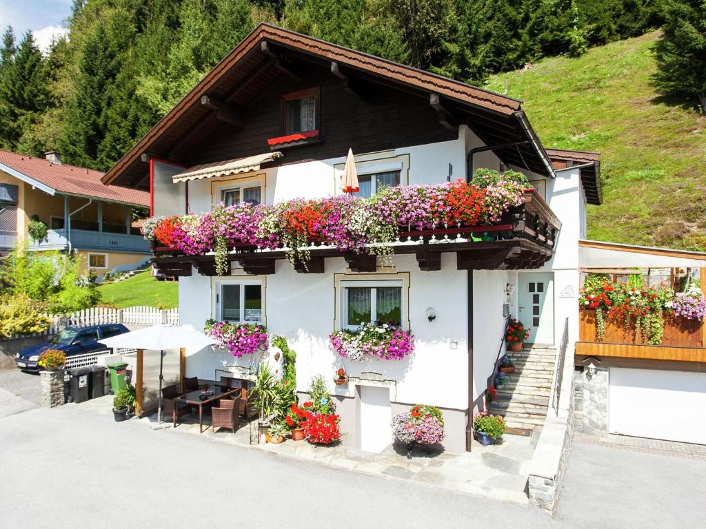 a white house with flowers on the side of it at Apartment near the ski area in Stuhlfelden in Stuhlfelden