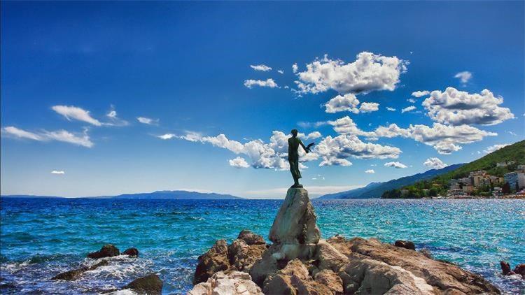 Ružići的住宿－HA-LU 1 - Holiday Relax Home，水中岩石上的男人雕像