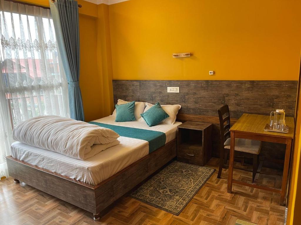 a bedroom with a bed and a desk and a table with a table at Munus Travel Home in Kathmandu