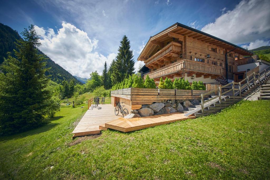 a large wooden building with a staircase in a field at Chalet Tannenbaum in Saalbach-Hinterglemm