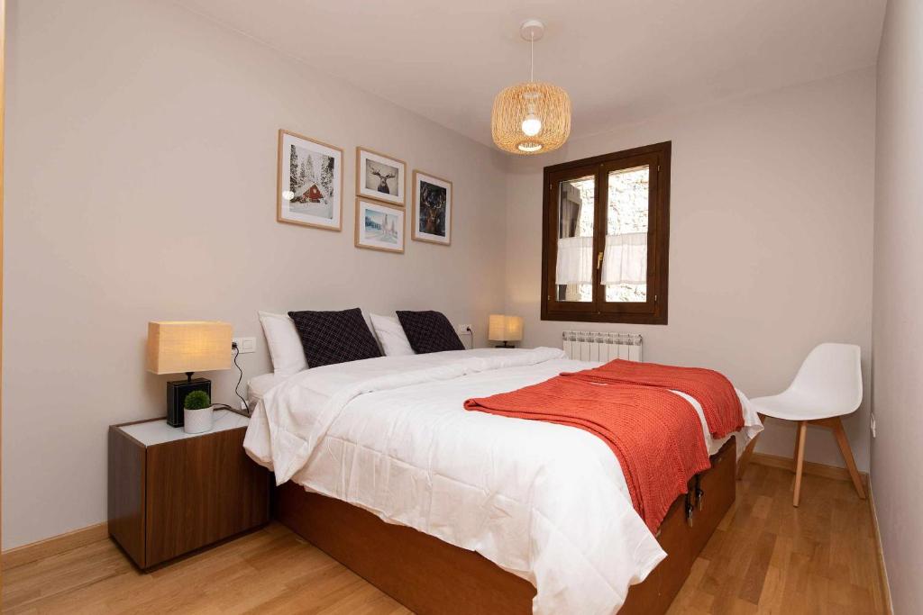 um quarto com uma cama com um cobertor vermelho em Casa de La Laguna by BeValle em Panticosa