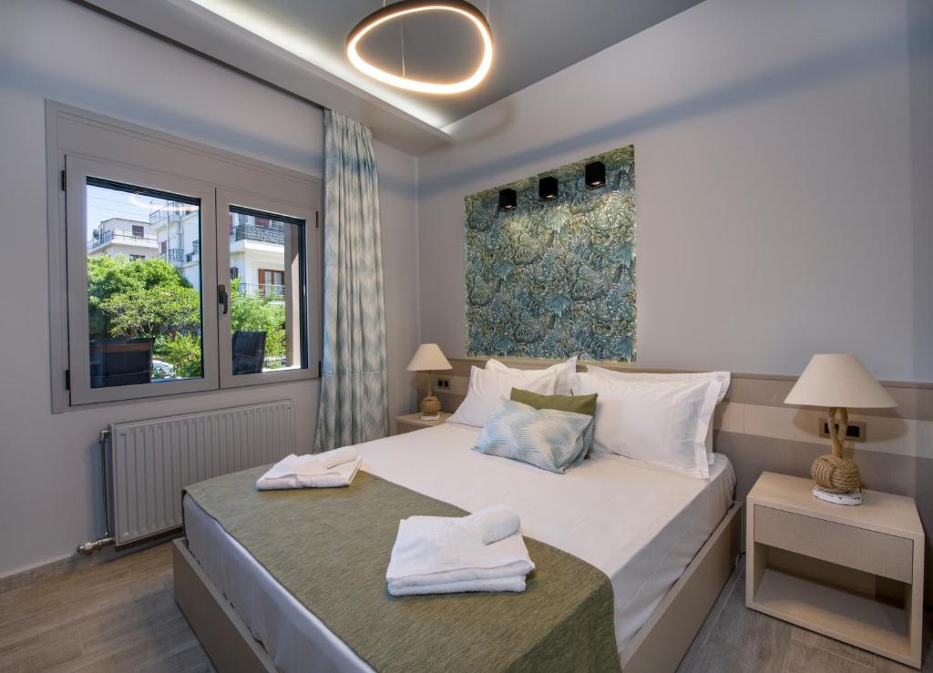 a bedroom with a large white bed and a window at Rena's luxury apartment with free private parking in Chania