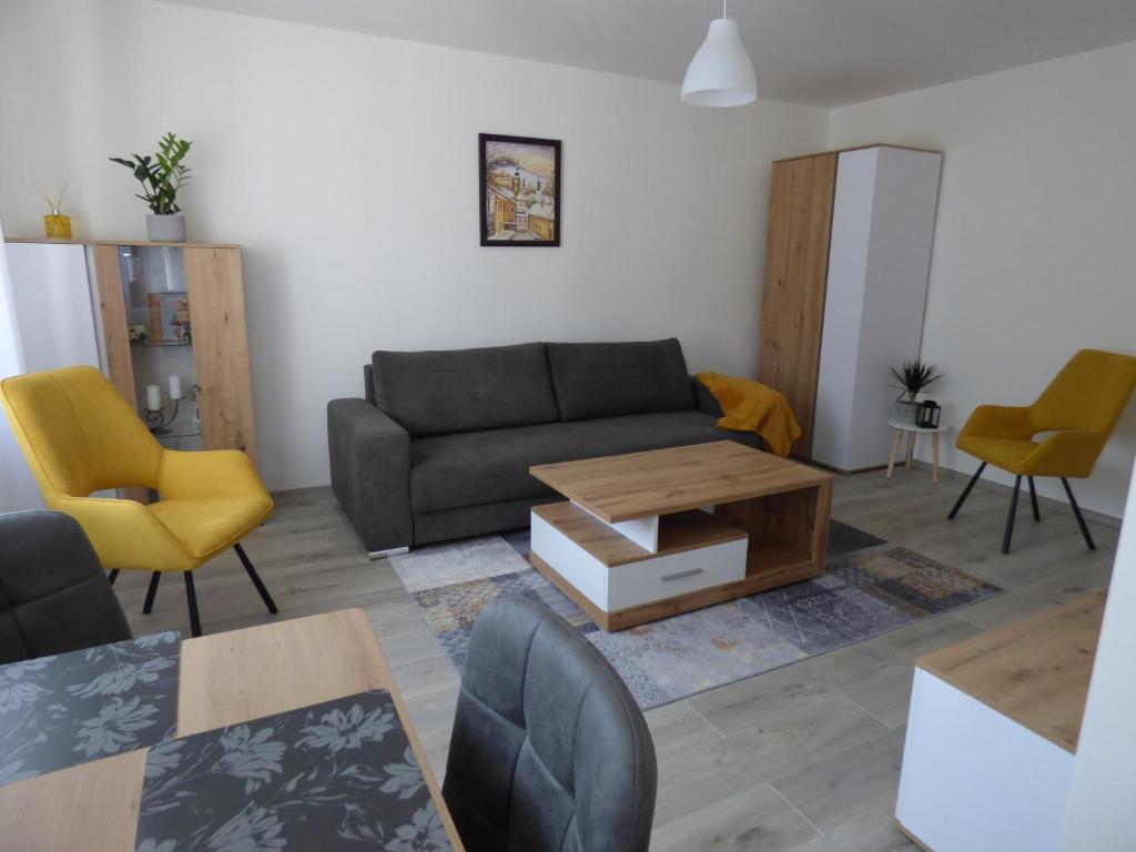 a living room with a couch and a table and chairs at Apartmán Dolinky in Vyhne