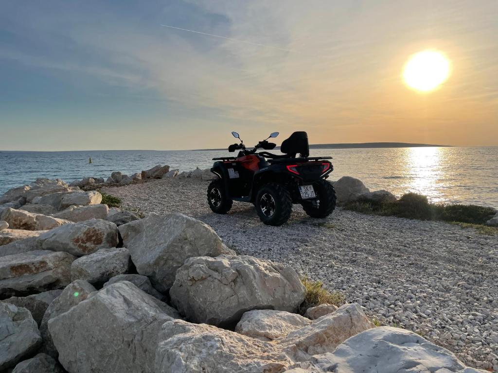 a motorcycle parked on a beach near the water at Apartments Gemma in Mandre
