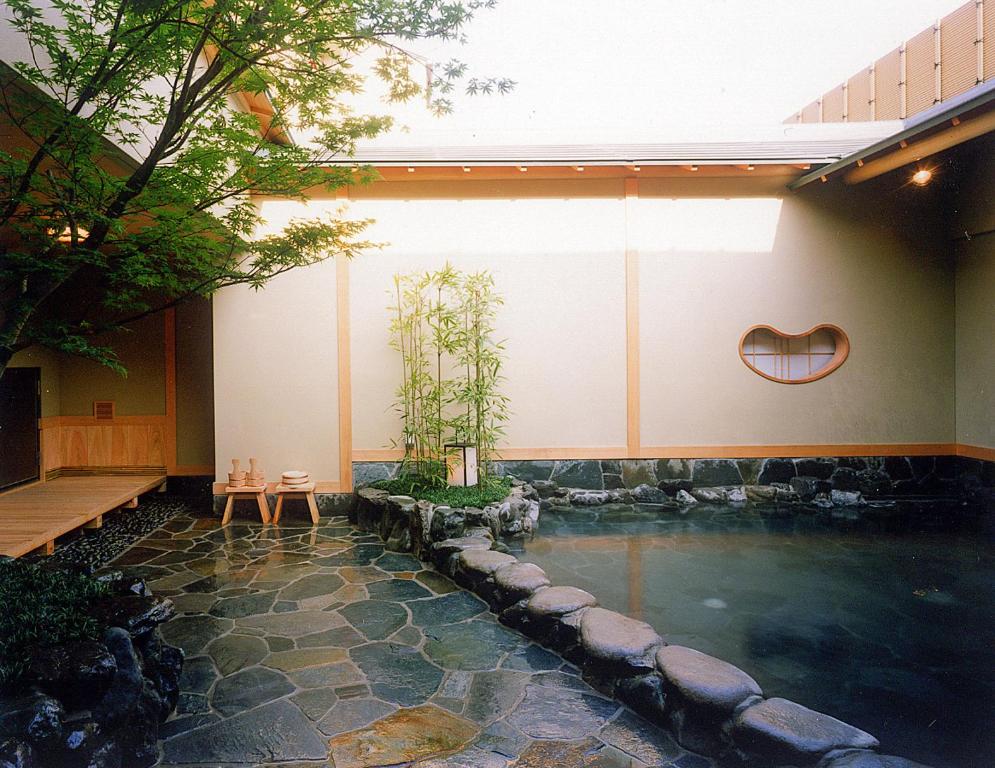 a pool of water with a bench and a house at Yuno Yado Shoei in Kyoto