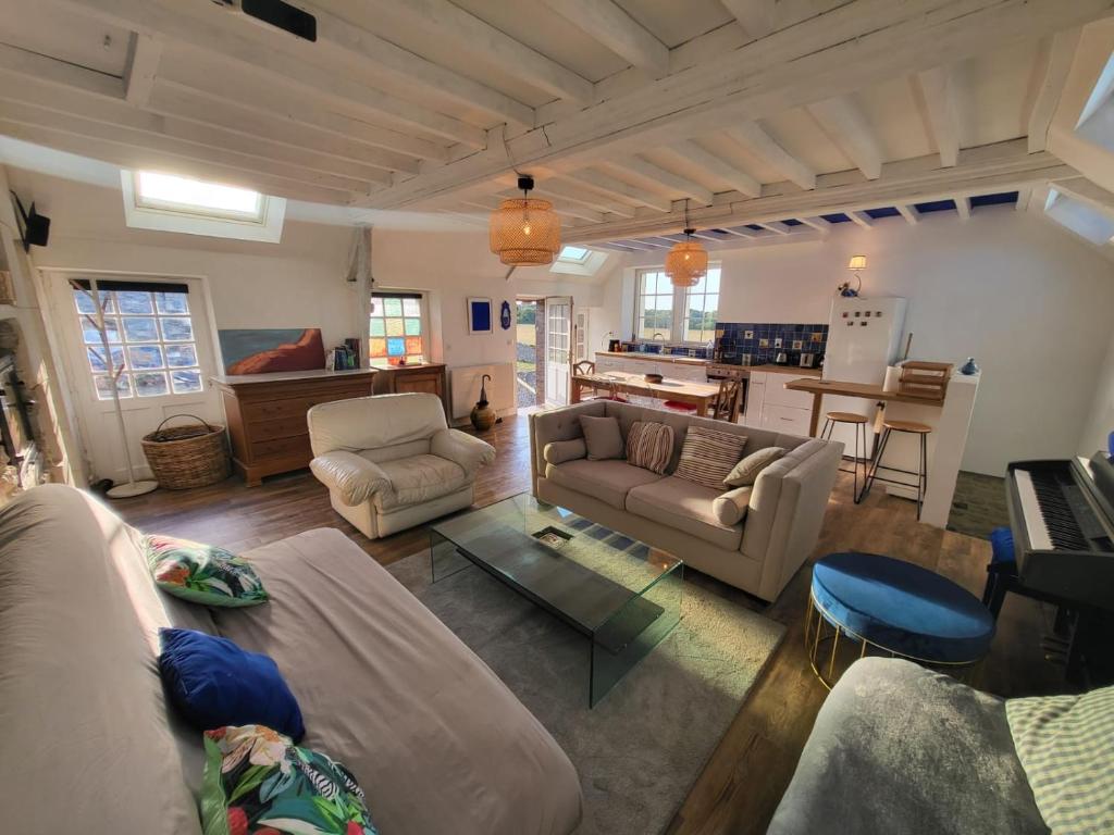 sala de estar con sofás, mesa y cocina en Casa Azul - Omaha Beach, en Colleville-sur-Mer