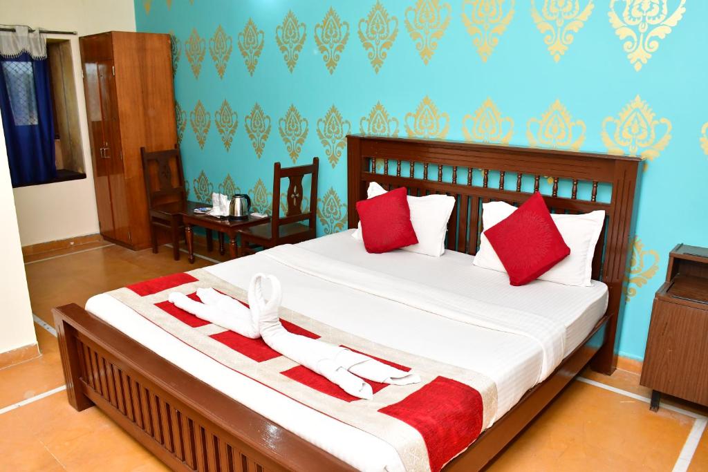 1 dormitorio con 1 cama grande con almohadas rojas en Sky View, en Jaisalmer
