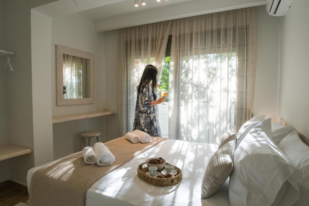 Una mujer mirando por la ventana de un dormitorio en Aesthisis Sensational Accommodation en Kolymbia