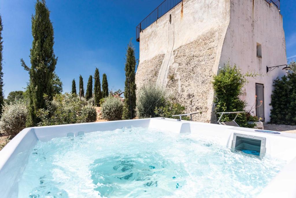 bañera de hidromasaje frente a un edificio en Antica Torre vista mare con jacuzzi - Apulia Home, en Capilungo