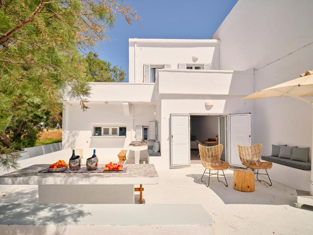 an outdoor patio with a table and chairs at Psathi Beach House in Kimolos