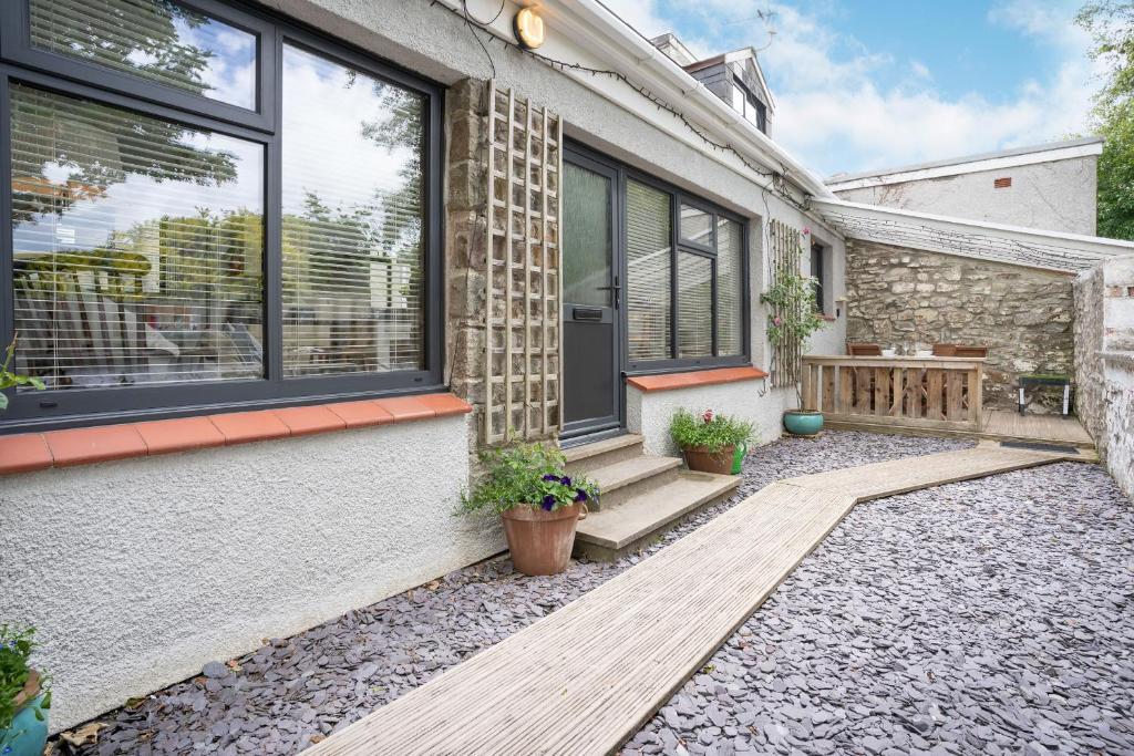 Casa con porche con banco y ventanas en Brewery Cottage, en Pontfaen