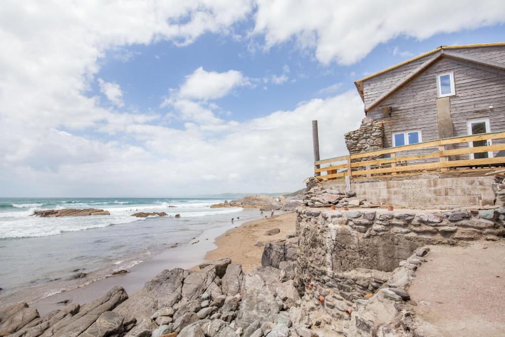 a house on the shore of a rocky beach at Beachcomber's Cottage in Millbrook