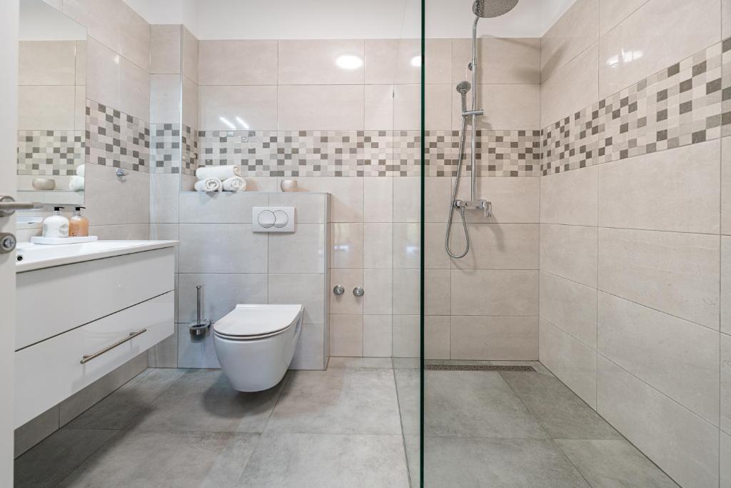 ein Badezimmer mit Toilette und Glasdusche in der Unterkunft Green Point Paklenica in Starigrad-Paklenica