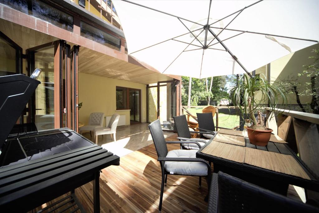 une terrasse avec une table, des chaises et un parasol dans l'établissement The Paradise House, à Riga