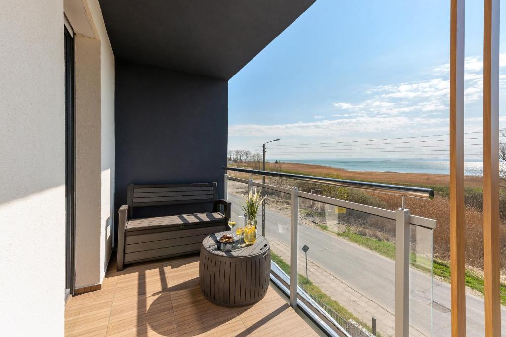 balkon ze stołem i widokiem na ocean w obiekcie BURSZTYNOVA Apartamenty Piamola w Kątach Rybackich