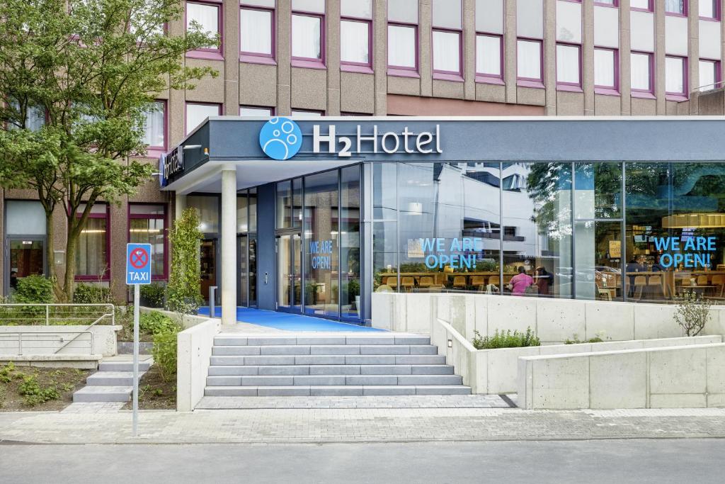 杜塞道夫的住宿－H2 Hotel Düsseldorf Seestern，前面有h酒店标志的建筑