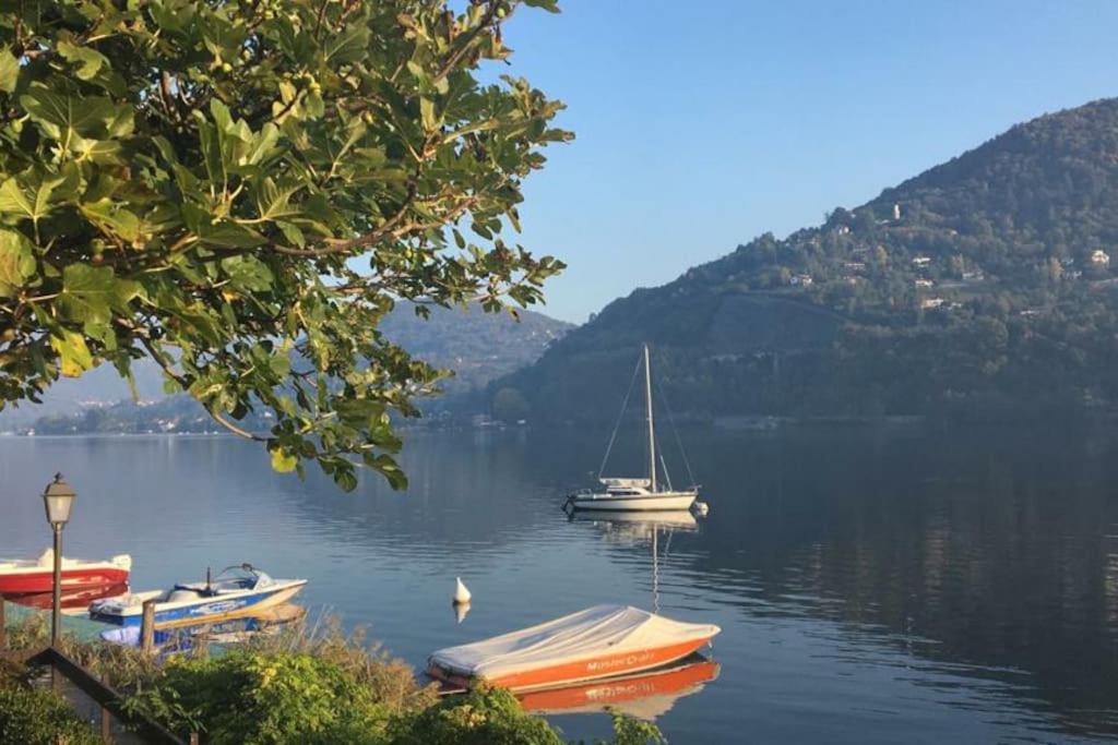 un groupe de bateaux sur un lac avec des montagnes dans l'établissement Lussuoso appartamento nella magia del lago d'Orta, à Orta San Giulio