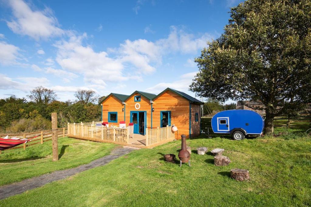 una casita en un campo con un remolque azul en Berrington Beach Hut, en Berwick-Upon-Tweed