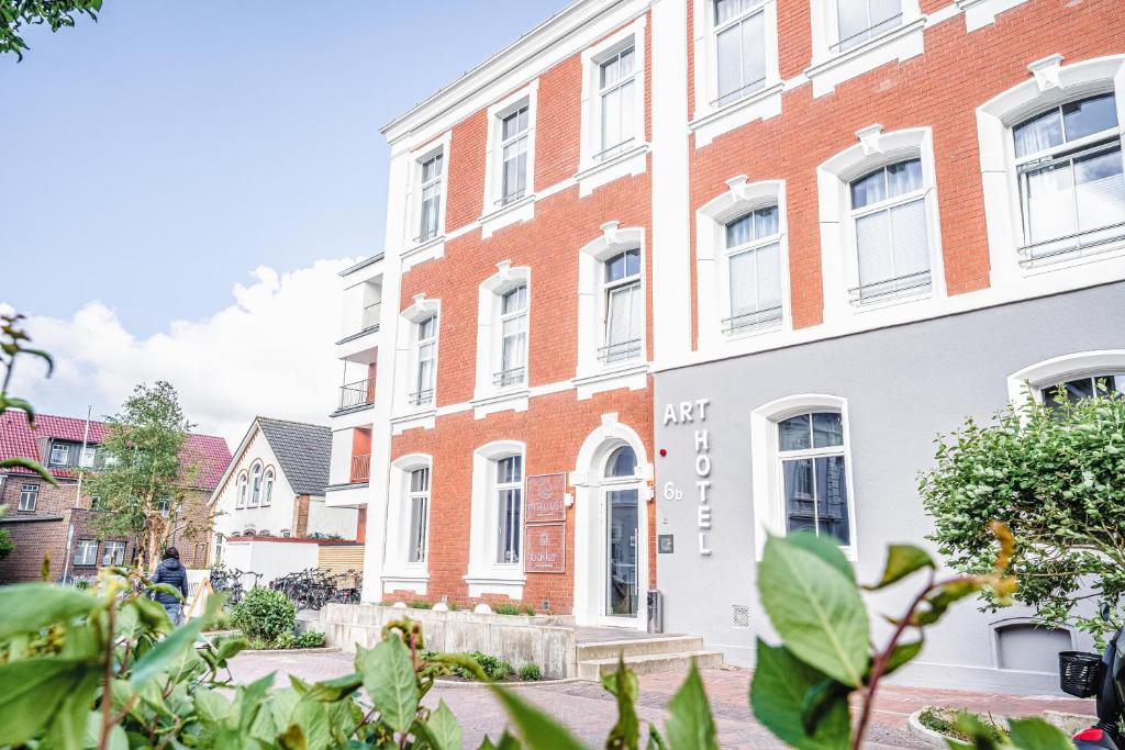 een appartementencomplex met witte en rode baksteen bij Arthotel Bakker in Borkum