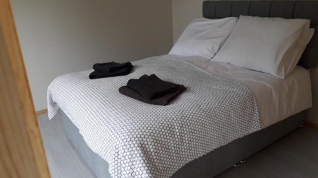 una cama con dos guantes negros sentados en ella en Dutchdream b&b logcabin en Eighter