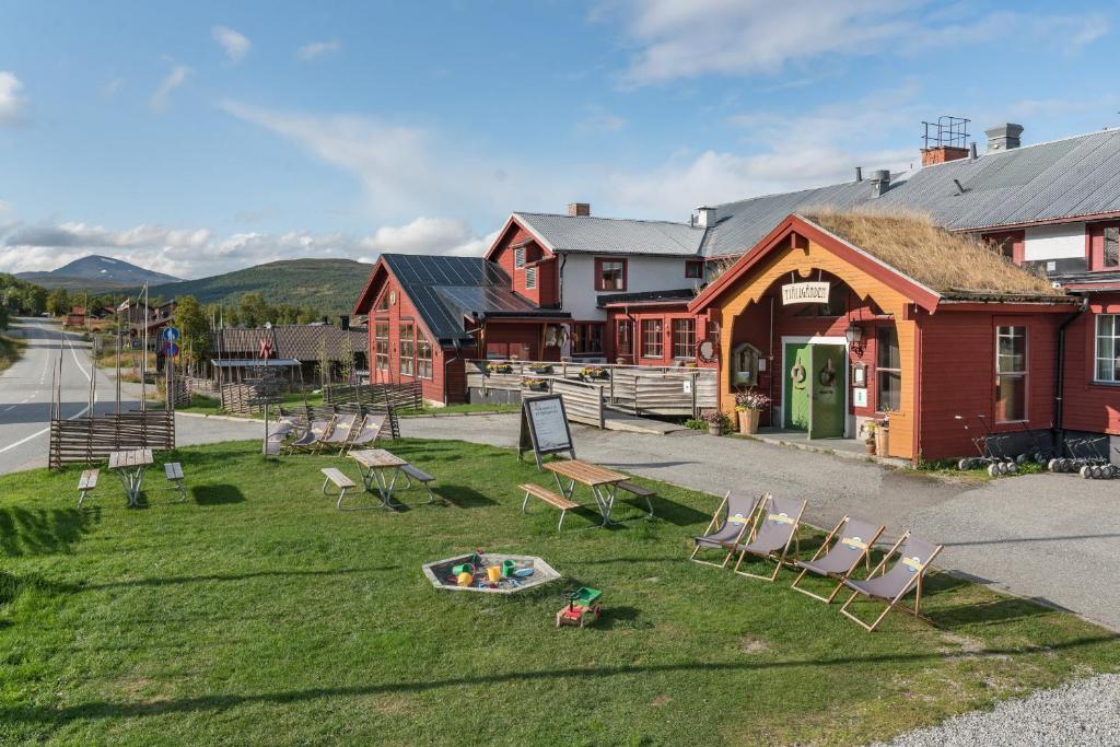 a group of chairs sitting on the grass in front of a building at Ramundbergets Fjällgård in Ramundberget