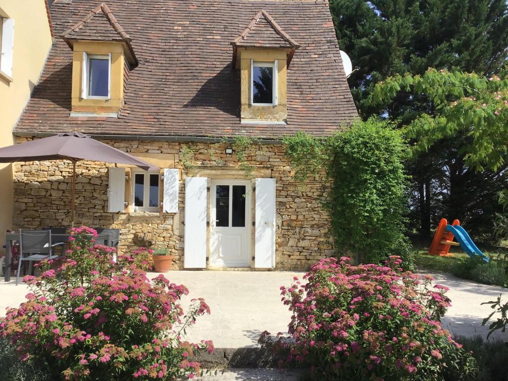 een huis met een witte deur en een speeltuin bij Beautiful 4 bedroom country cottage sleeps 7 in Saint-Cybranet
