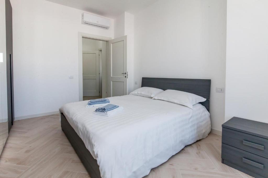 sypialnia z dużym białym łóżkiem i komodą w obiekcie 12° Piano Torre Diamante - 67 w Mediolanie
