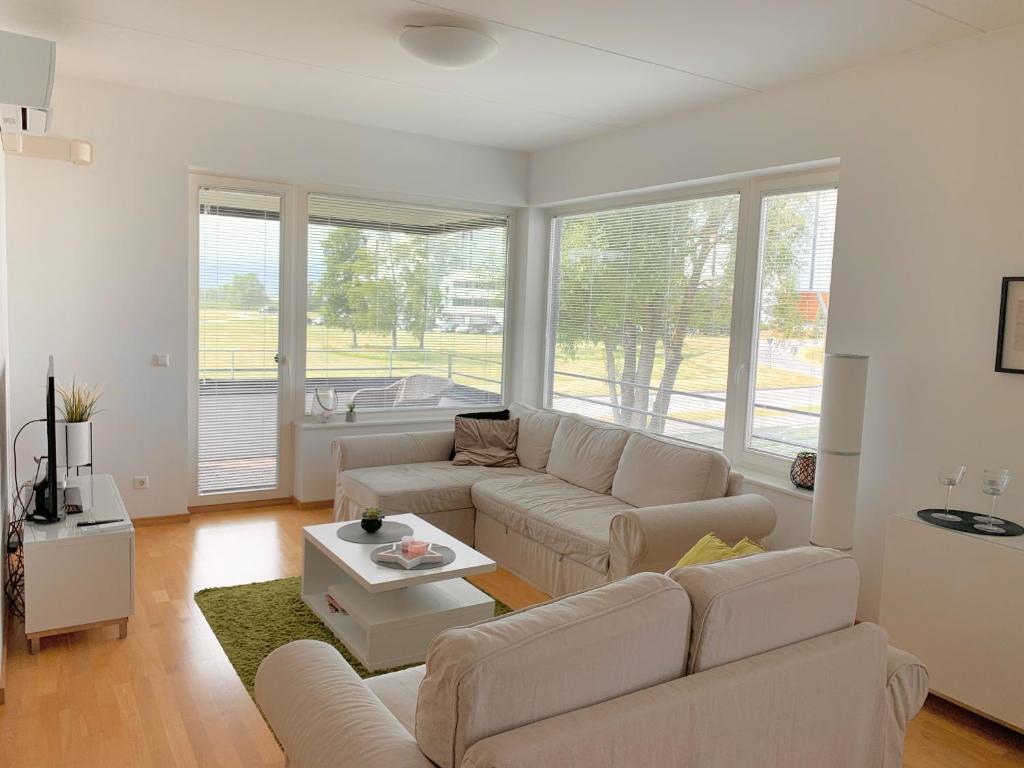 a living room with white furniture and large windows at Papli Seaview Apartment in Pärnu