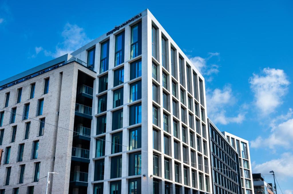 un edificio de oficinas con un cielo azul en el fondo en Staycity Aparthotels Dublin City Quay en Dublín