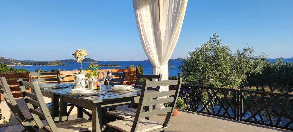 un tavolo su un balcone con vista sull'acqua di Holiday House Lucy a Pakoštane