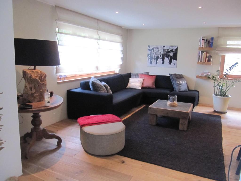 un soggiorno con divano nero e tavolo di Swissalpschalet Chalet Timber Inn 4-5 a Blatten bei Naters