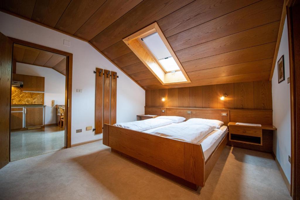 a bedroom with a large wooden bed with a skylight at Apartments Zilli in Laion