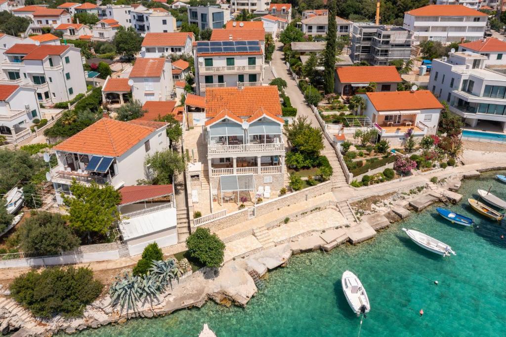 an aerial view of a house with a boat in the water at Villa Blanka Apartments in Rogoznica
